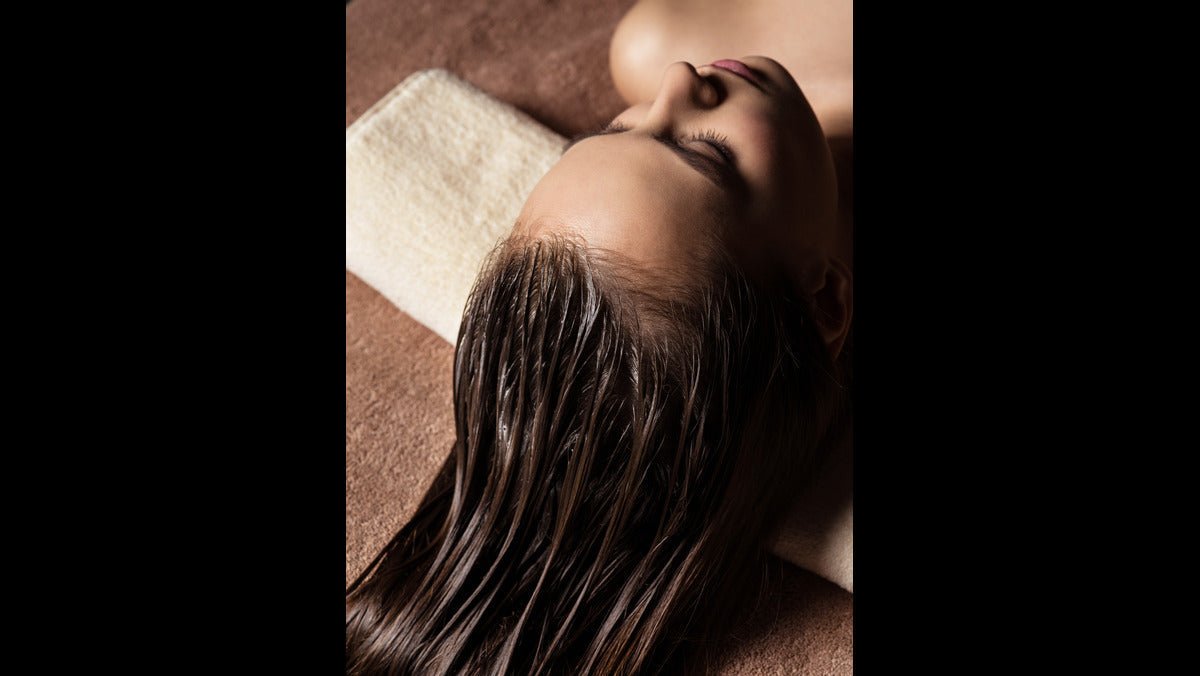 A woman with voluminous hair after using a bottle of Revival Scalp Wash. 
