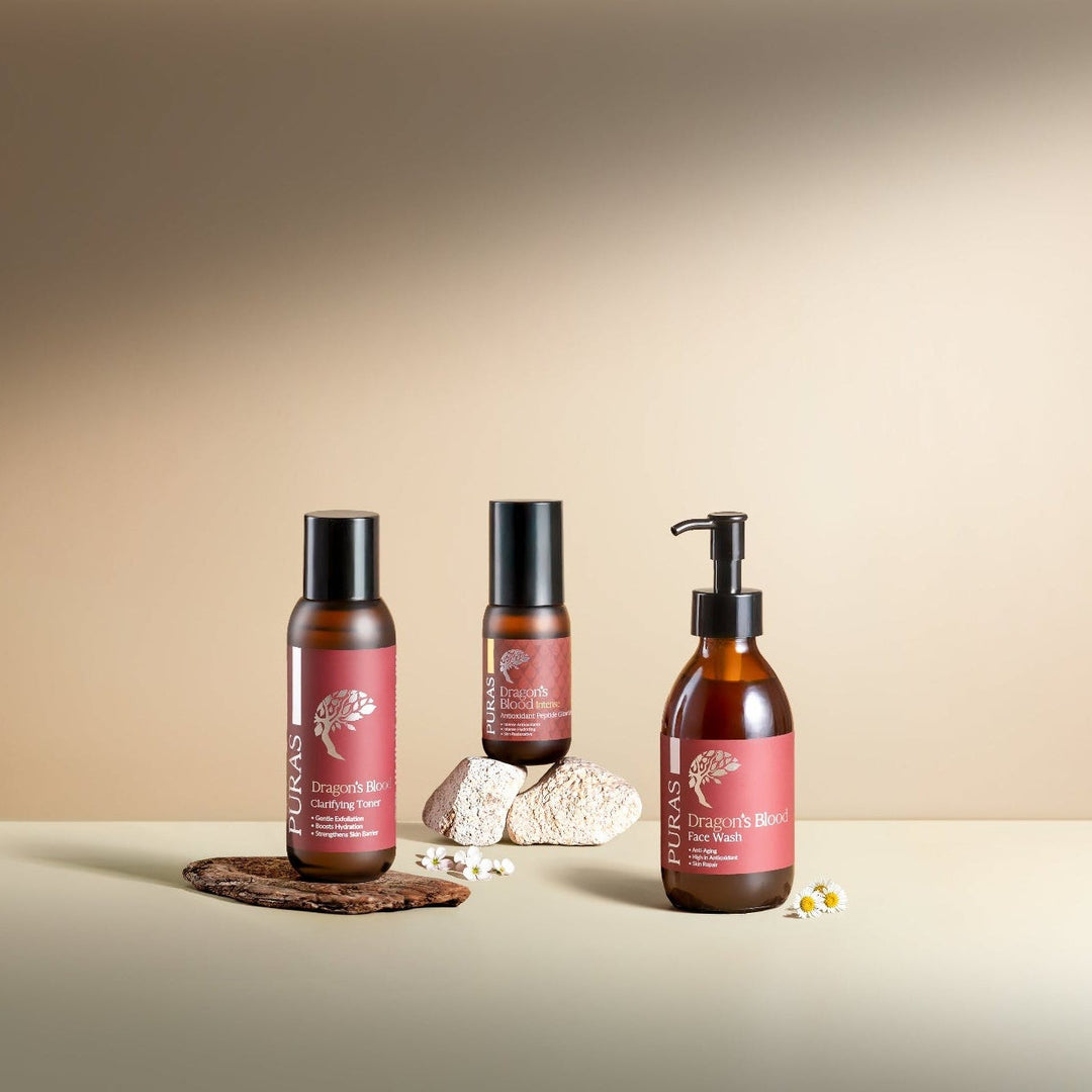 Three DB skincare bottles with red labels on a beige background