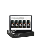 Puras essential oils gift set in a black presentation box with five small dark bottles displayed inside on a white insert, with the brand name PURAS printed on the front of the box.