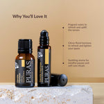 Two bottles of PURAS essential oils on a marble surface with a beige background.
