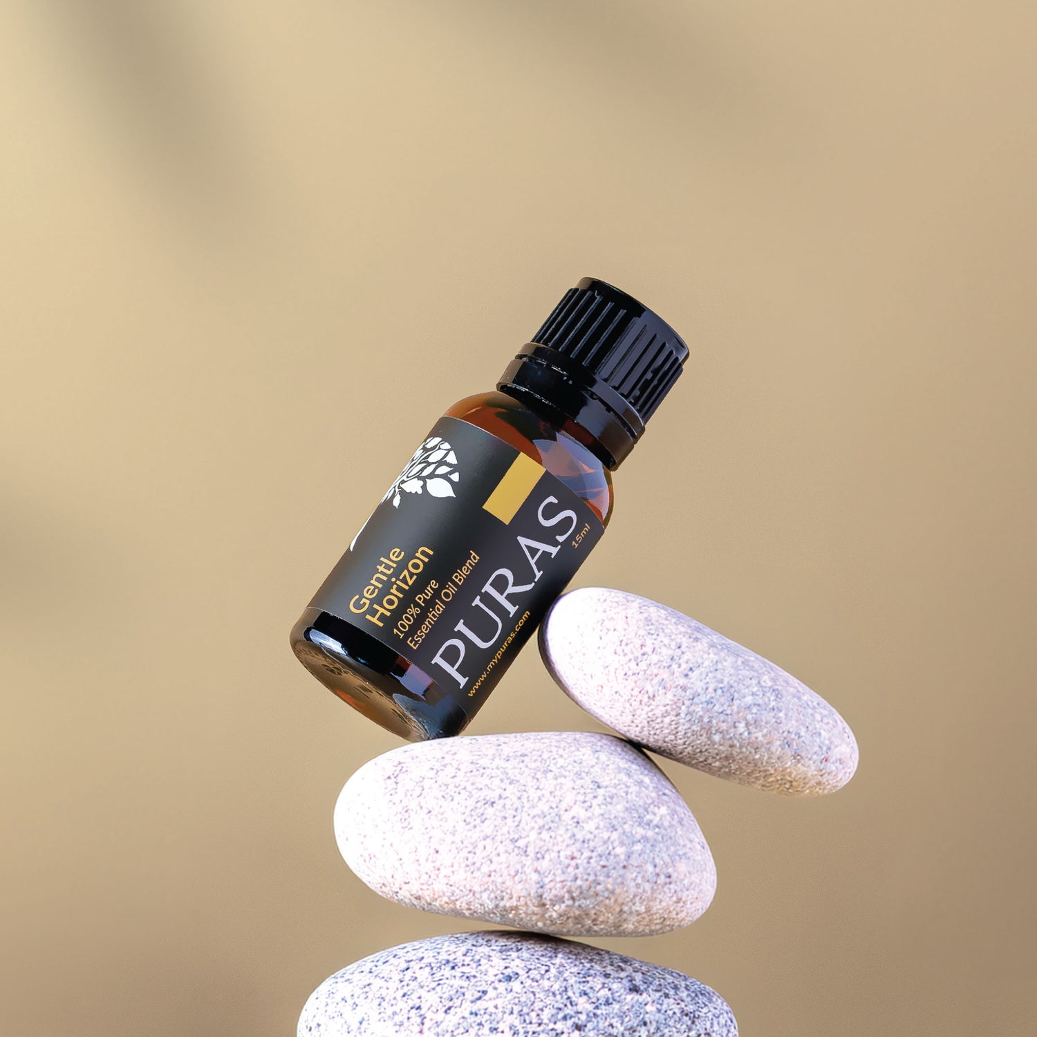 Puras essential oil bottle balanced on stones with a beige background